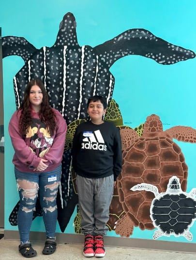 students posing with a turtle painting
