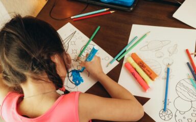 Student drawing in her home